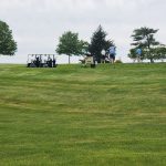 Panoramic view of a lush green golf course at Juniper Hill Golf Course. Smooth