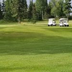 Panoramic view of a lush green golf course at Kenai Golf Course. Smooth