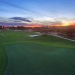 Panoramic view of a lush green golf course at Kissing Tree Golf Club. Smooth
