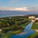 Panoramic view of a lush green golf course at Kiva Dunes Public Golf Course. Smooth