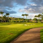 Panoramic view of a lush green golf course at Kukui`ula Golf Course. Smooth