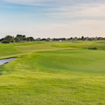 Panoramic view of a lush green golf course at LaTour Golf Club. Smooth