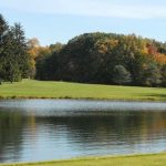 Panoramic view of a lush green golf course at Lake Arthur Golf Club. Smooth