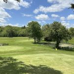 Panoramic view of a lush green golf course at Lake Beulah Country Club. Smooth