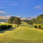 Panoramic view of a lush green golf course at Lambert Acres Golf Club. Smooth