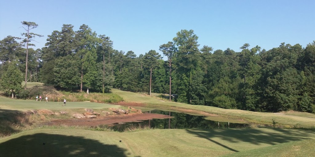 Panoramic view of a lush green golf course at Legacy Golf Links & Driving Range. Smooth
