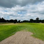 Panoramic view of a lush green golf course at Leonard Country Club. Smooth