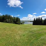 Panoramic view of a lush green golf course at Lochmor Golf Course. Smooth