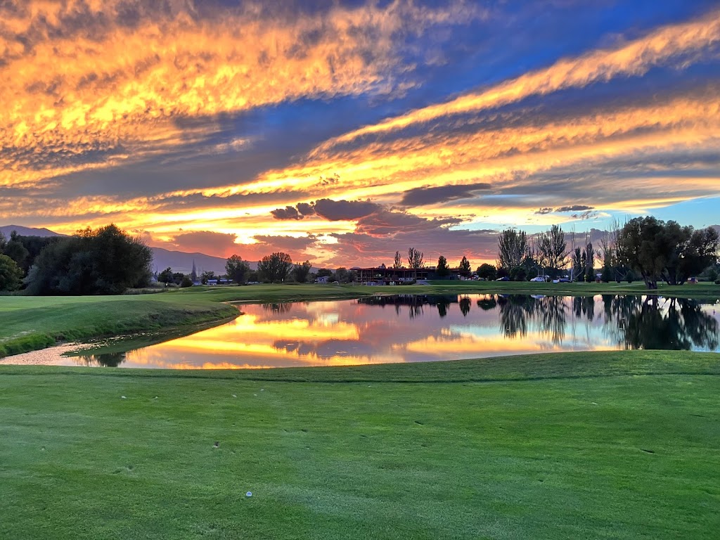 Panoramic view of a lush green golf course at Logan River Golf Course. Smooth