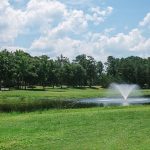 Panoramic view of a lush green golf course at Lost Plantation Golf Club. Smooth