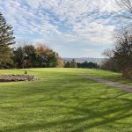 Panoramic view of a lush green golf course at Lyons Den Golf Course. Smooth