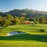 Panoramic view of a lush green golf course at Maderas Golf Club. Smooth