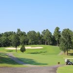 Panoramic view of a lush green golf course at Magellan Golf Club. Smooth