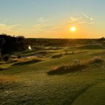 Panoramic view of a lush green golf course at Mammoth Dunes. Smooth