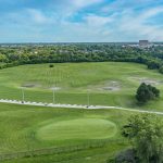 Panoramic view of a lush green golf course at Marquette Park Golf Course. Smooth