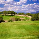 Panoramic view of a lush green golf course at Marty Sanchez Links de Santa Fe Golf Course. Smooth