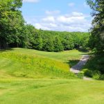 Panoramic view of a lush green golf course at Michaywe Pines Golf Course. Smooth