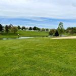 Panoramic view of a lush green golf course at Moccasin Run Golf Club. Smooth