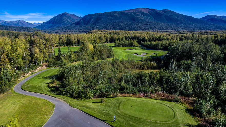 Panoramic view of a lush green golf course at Moose Run Golf Course. Smooth
