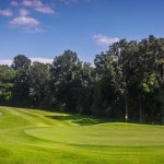 Panoramic view of a lush green golf course at Nashville National Golf Links. Smooth