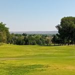 Panoramic view of a lush green golf course at New Mexico Tech Golf Course. Smooth