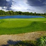 Panoramic view of a lush green golf course at Noble Hawk Golf Links. Smooth