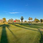 Panoramic view of a lush green golf course at North Kern Golf Course. Smooth