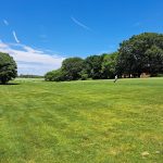 Panoramic view of a lush green golf course at North Kingstown Golf Course. Smooth