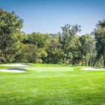 Panoramic view of a lush green golf course at Northwest Golf Course. Smooth