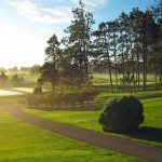 Panoramic view of a lush green golf course at Oak Hill Golf Club. Smooth