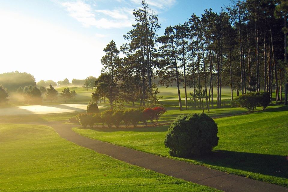 Panoramic view of a lush green golf course at Oak Hill Golf Club. Smooth