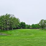 Panoramic view of a lush green golf course at Oak Hills Golf Course. Smooth