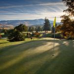 Panoramic view of a lush green golf course at Oak Knoll Golf Course. Smooth