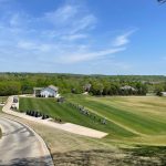 Panoramic view of a lush green golf course at Oaks Country Club. Smooth