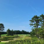 Panoramic view of a lush green golf course at Old Sandwich Golf Club. Smooth