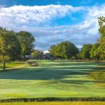 Panoramic view of a lush green golf course at Old Town Club. Smooth