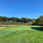 Panoramic view of a lush green golf course at Olde Scotland Links. Smooth