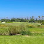 Panoramic view of a lush green golf course at Olivas Links. Smooth