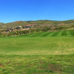 Panoramic view of a lush green golf course at Outlaw Golf Club. Smooth