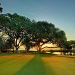 Panoramic view of a lush green golf course at Oyster Reef Golf Club. Smooth