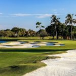 Panoramic view of a lush green golf course at PGA National Members Club. Smooth