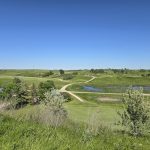 Panoramic view of a lush green golf course at Painted Woods. Smooth