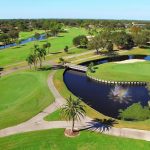 Panoramic view of a lush green golf course at Palm Aire Country Club. Smooth