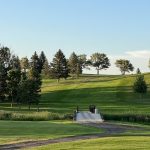 Panoramic view of a lush green golf course at Peaceful Valley Golf Course. Smooth