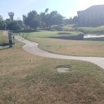 Panoramic view of a lush green golf course at Pebble Creek Golf Course Mustang. Smooth
