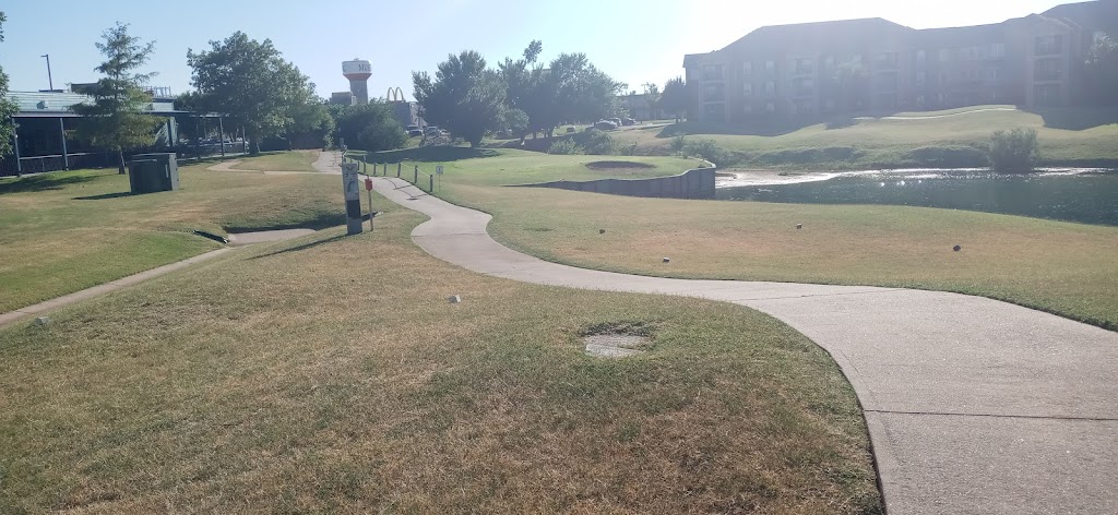 Panoramic view of a lush green golf course at Pebble Creek Golf Course Mustang. Smooth