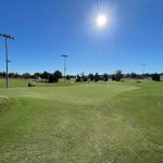 Panoramic view of a lush green golf course at Pecan Hollow Golf Course. Smooth