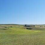 Panoramic view of a lush green golf course at Pelican Beach Golf Course. Smooth