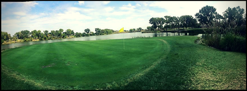 Panoramic view of a lush green golf course at Pine Bay Golf Course. Smooth