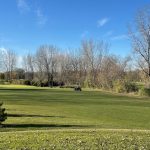 Panoramic view of a lush green golf course at Pine Island Golf Course. Smooth